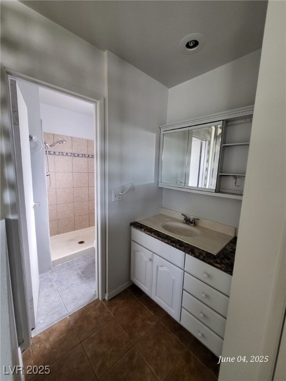 Bathroom with a stall shower, vanity, and tile pat