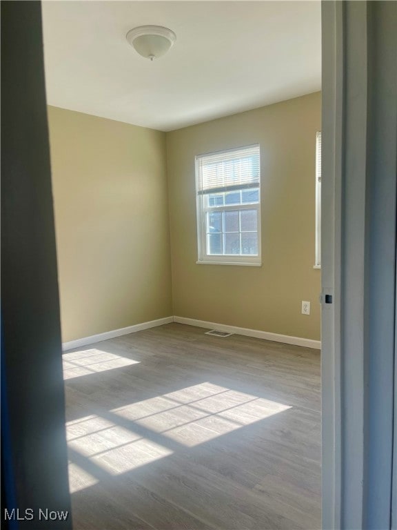 Empty room featuring baseboards and light wood-style floors