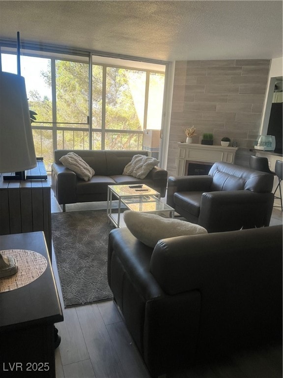 Living area with a fireplace, wood finished floors, and a textured ceiling