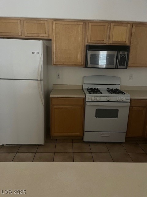 Kitchen featuring range, light tile patterned floo