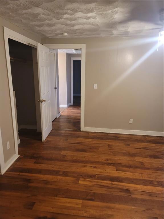 Spare room featuring dark wood finished floors