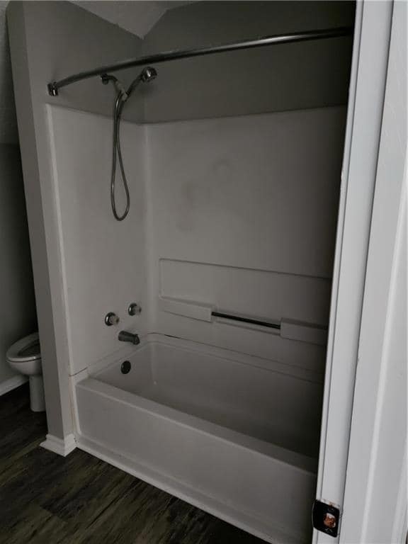 Bathroom featuring wood finished floors, baseboards, a textured ceiling, vanity, and vaulted ceiling