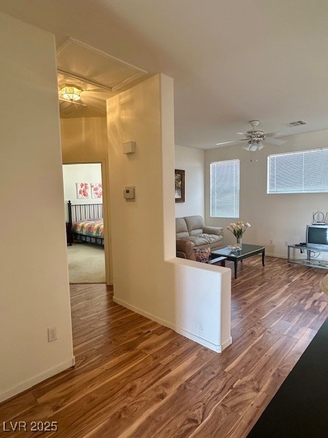 Hall with baseboards, visible vents, wood finished
