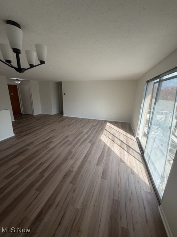 Unfurnished living room featuring wood finished floors and a textured ceiling
