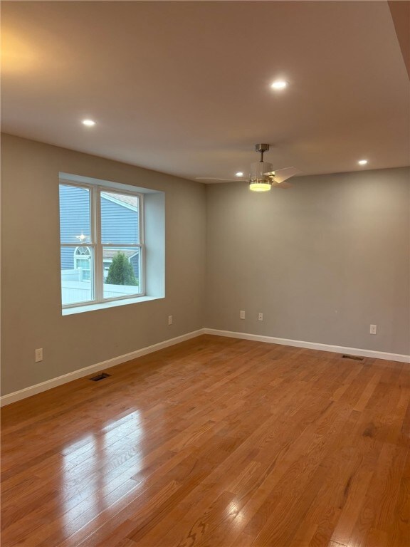 Spacious living room with recessed lighting and ceiling fan.
