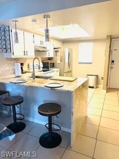 Kitchen with stainless steel microwave, under cabi