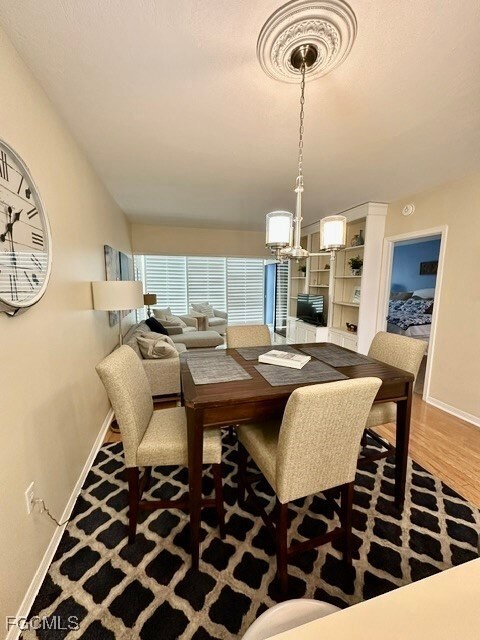 Dining area featuring an inviting chandelier and hardwood / wood-style flooring