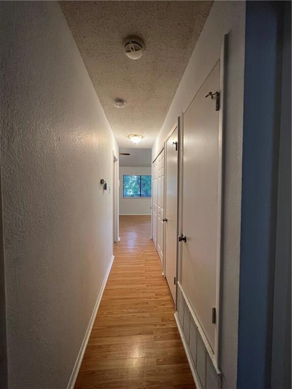 Corridor with light wood finished floors, a textu