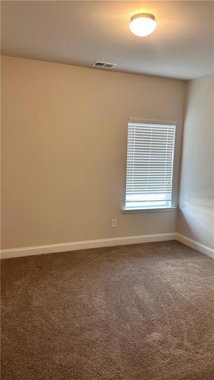 Empty room featuring carpet floors and baseboards