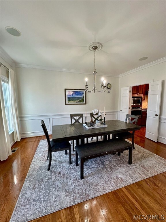 Dining area featuring ornamental molding, a chande