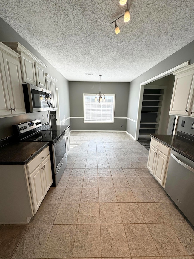 Kitchen with hanging light fixtures, light tile fl