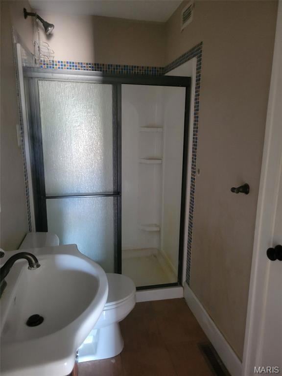 Full bath featuring a shower stall and tile patterned floors