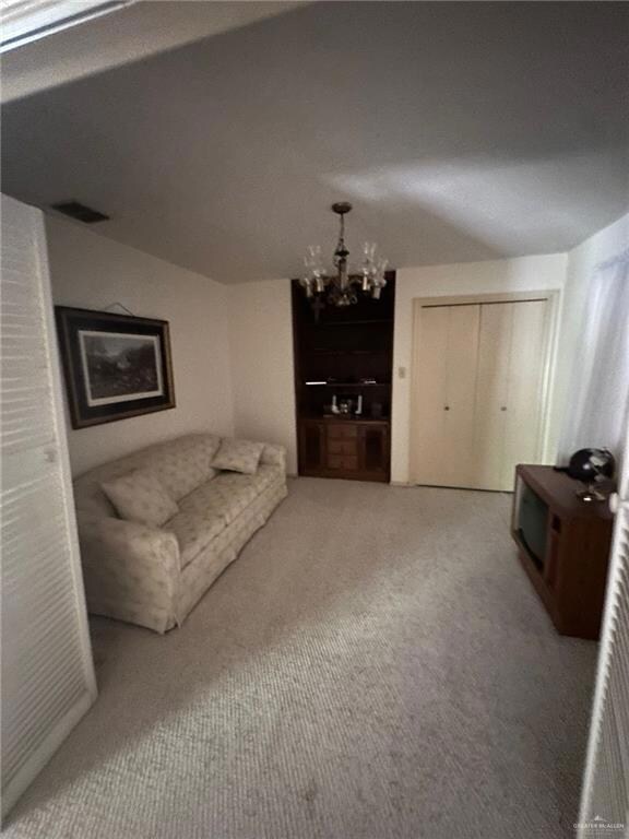 Living room featuring carpet and a chandelier