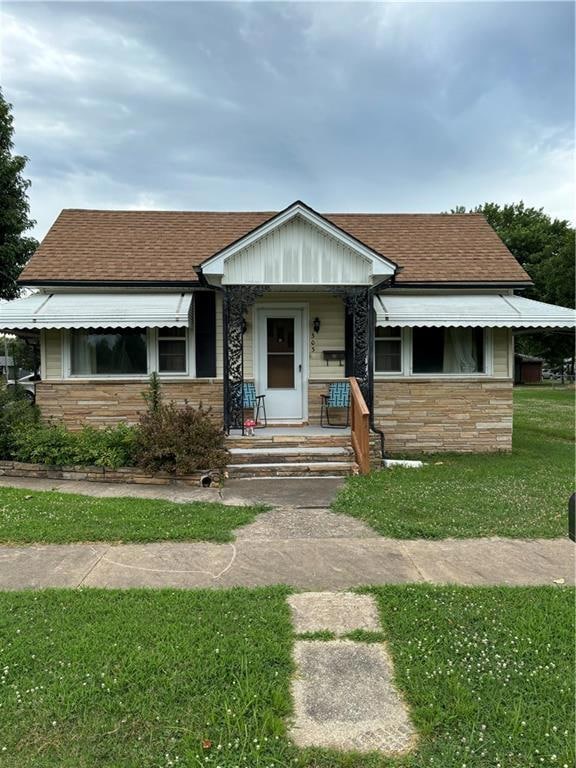 View of front facade with a front lawn and covered porch