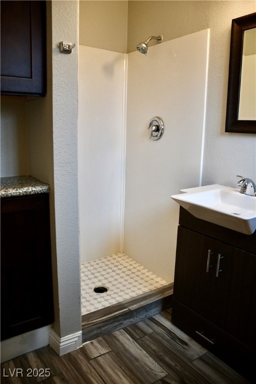 Bathroom with a stall shower, vanity, and vinyl fl