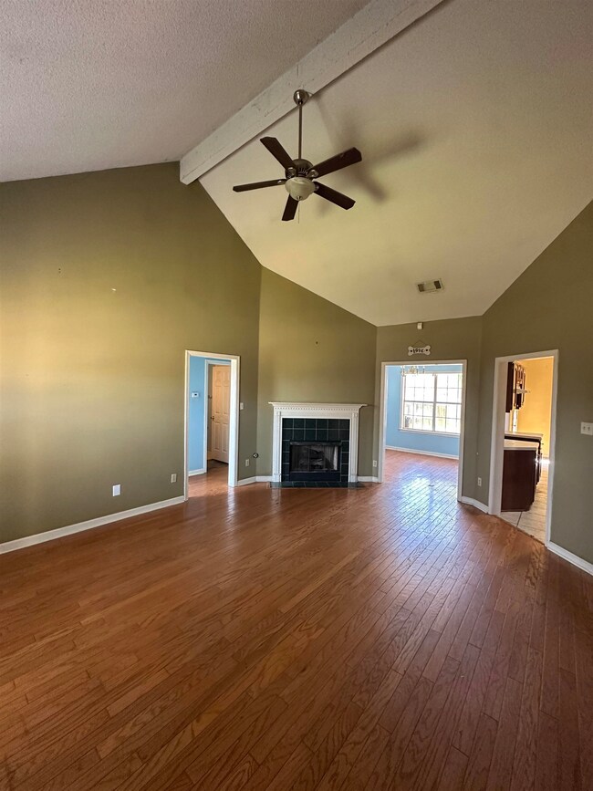 Unfurnished living room with a tiled fireplace, a 