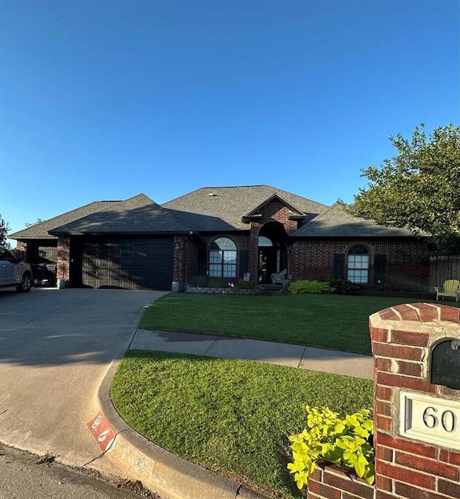 View of front of property with a garage and a front lawn