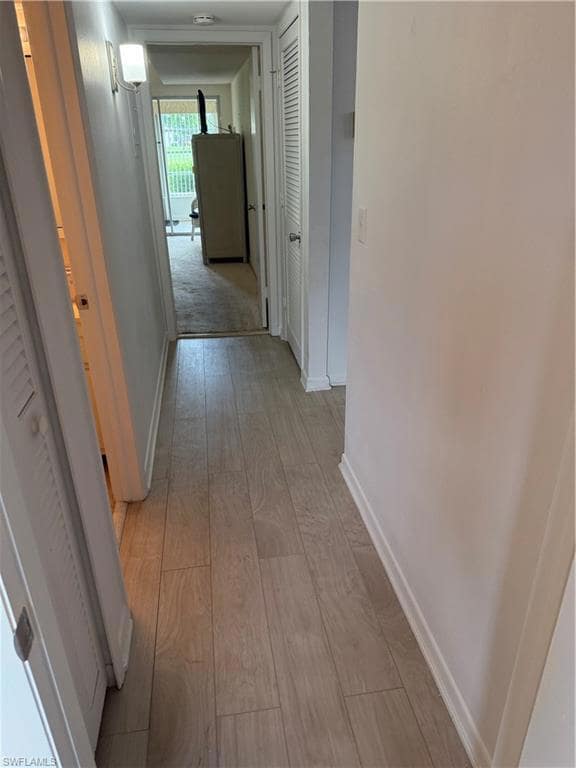 Hallway with baseboards and light wood finished floors