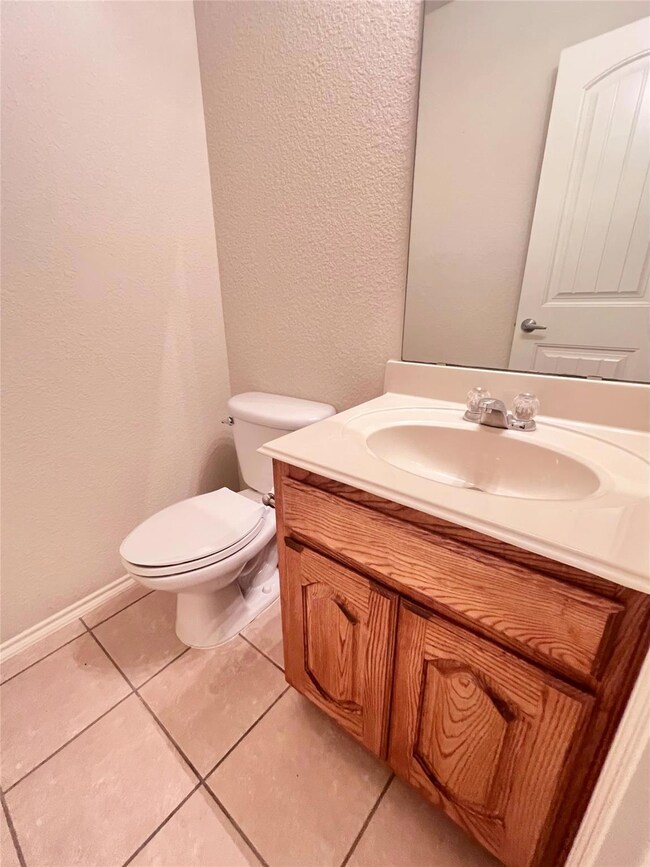 Half Bathroom featuring vanity, toilet, and tile f