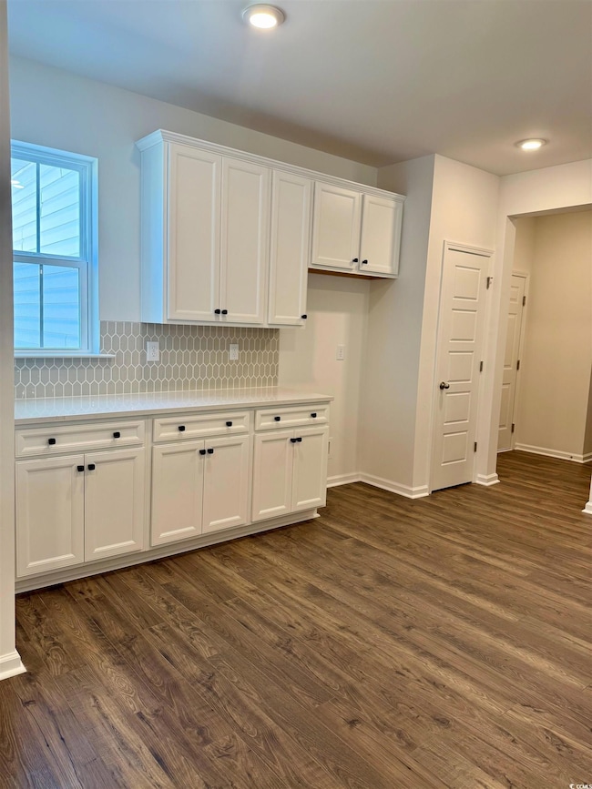 Kitchen with light countertops, white cabinets, an