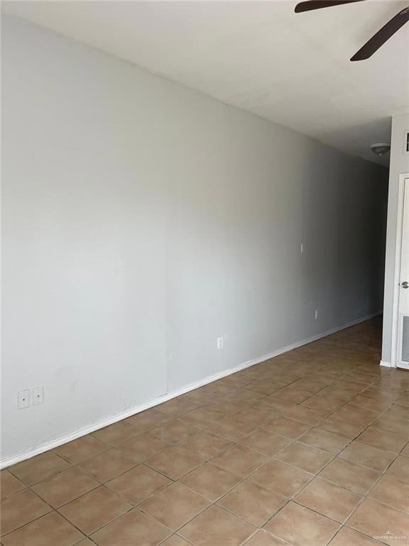 Unfurnished room featuring light tile patterned floors and a ceiling fan