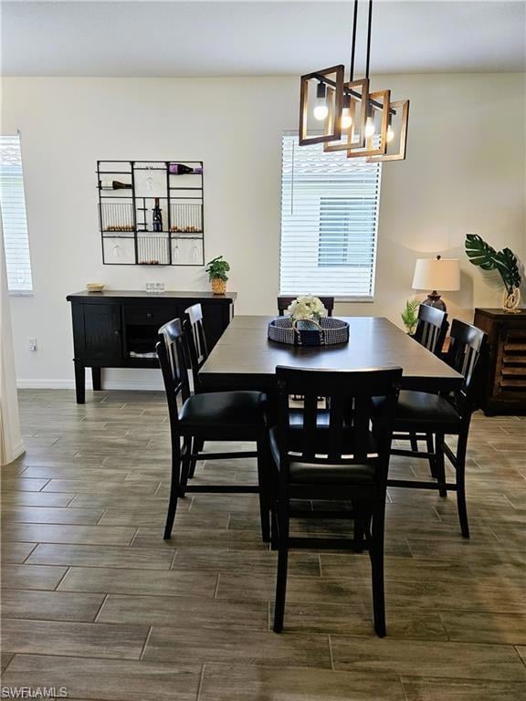 Dining space featuring baseboards, wood tiled floo