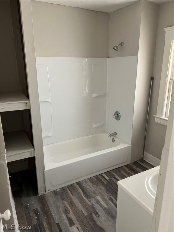 Bathroom with shower / bathing tub combination and hardwood / wood-style flooring