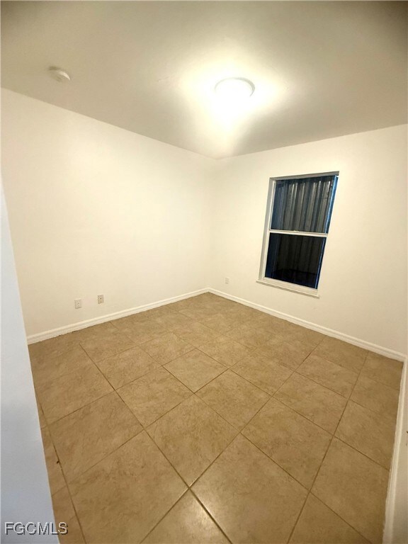 Spare room with tile patterned floors and baseboards