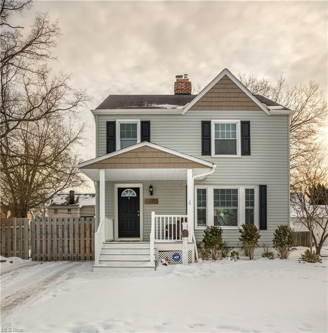 The front entryway is highlighted by a covered porch and contrasting shingled siding.