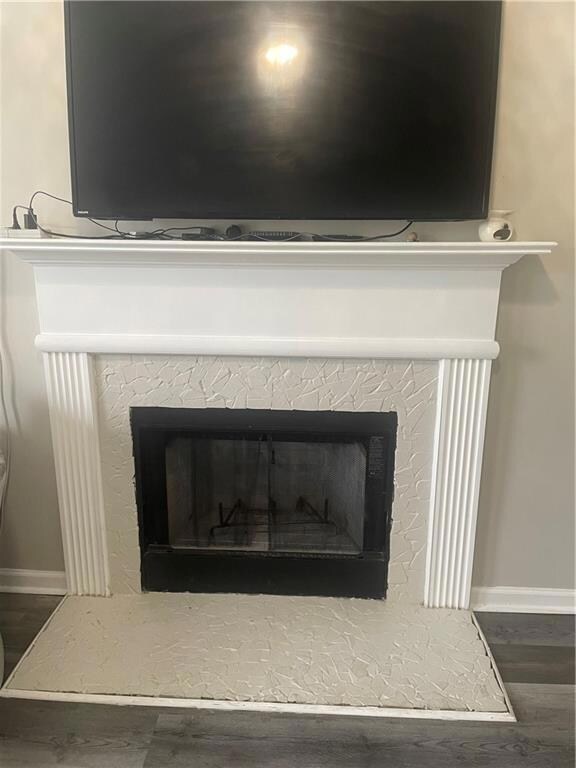 Detailed view of wood finished floors and a fireplace with raised hearth