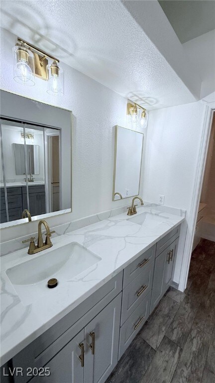 Full bath featuring double vanity, a textured ceil