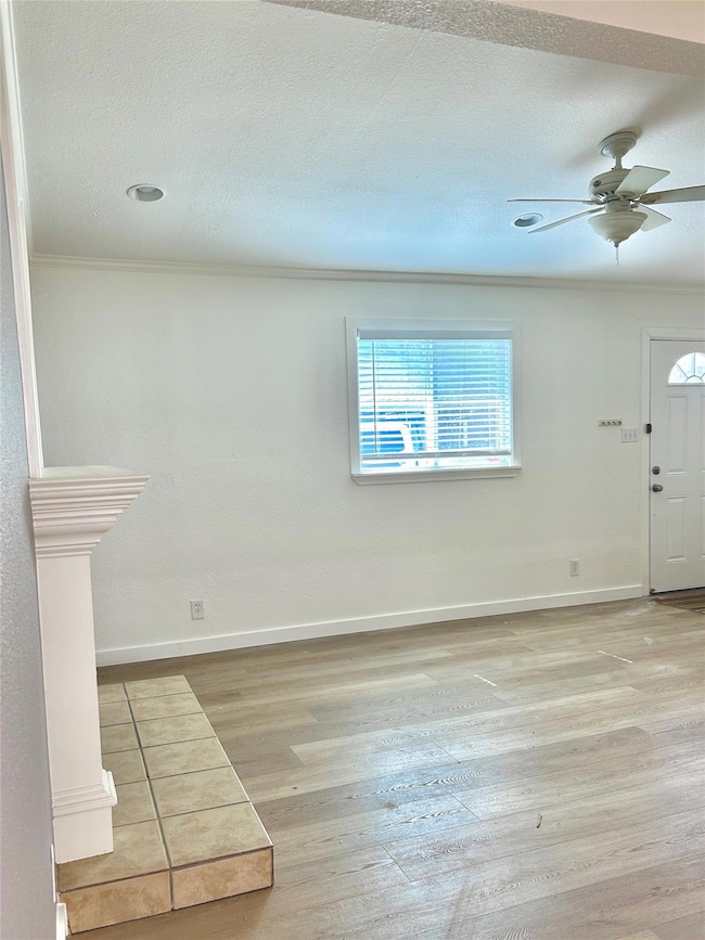 Foyer with wood finished floors, ceiling fan, cro