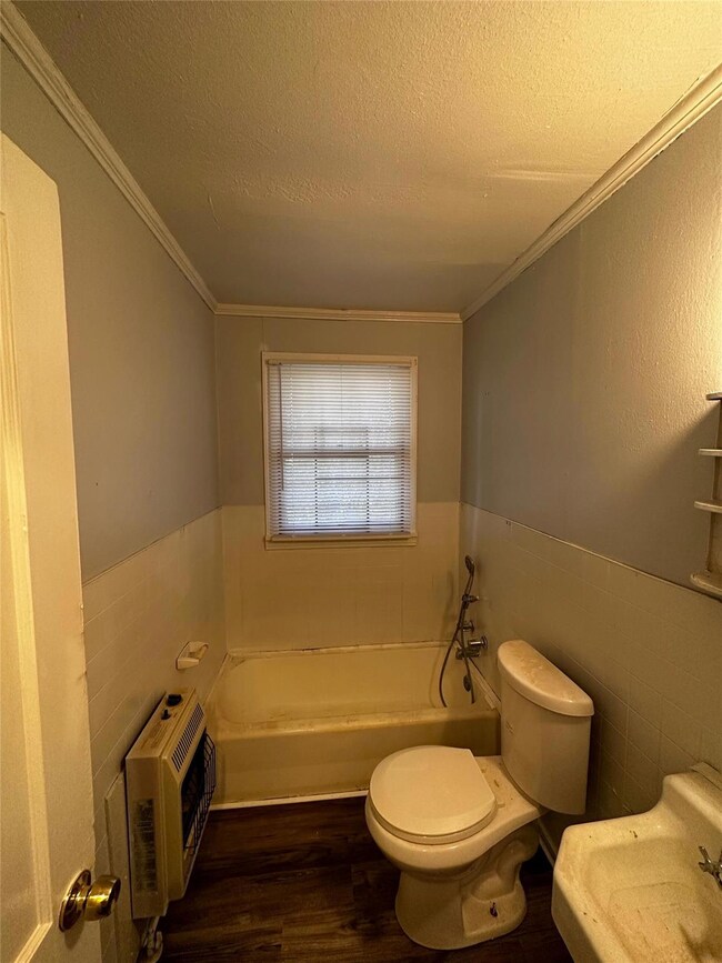 Bathroom featuring a textured ceiling, a bathing t