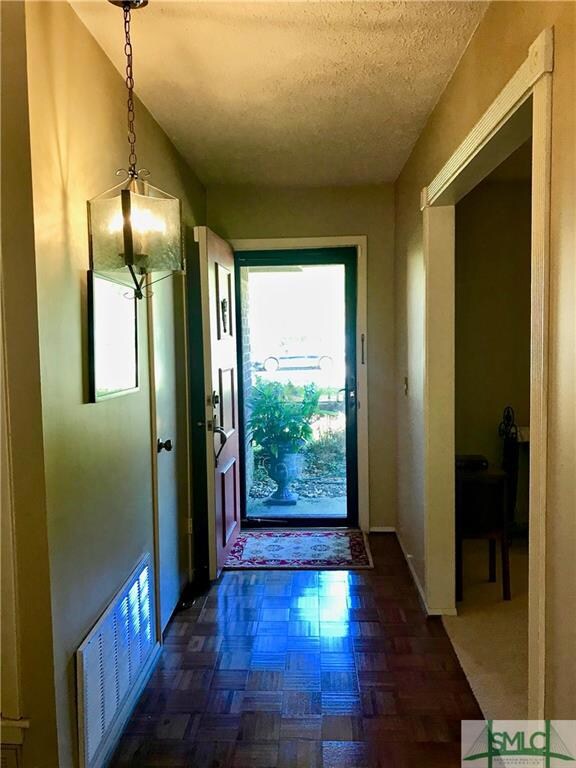 Parquet floored entry with original light fixture.