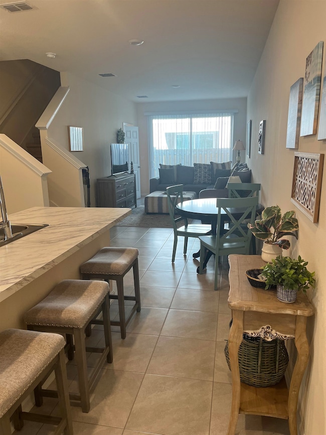 Living area with light tile patterned floors and stairs