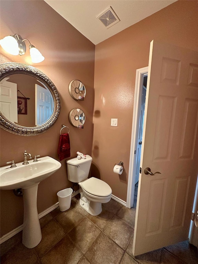 Half bathroom featuring baseboards, visible vents,