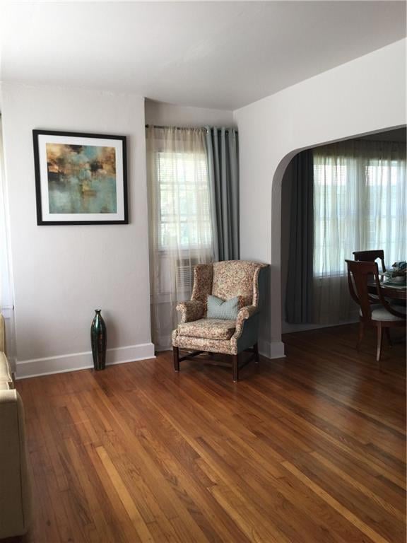 Living area featuring baseboards, arched walkways,