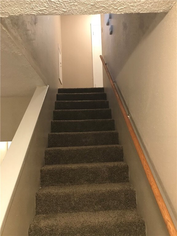 Stairs featuring a textured ceiling