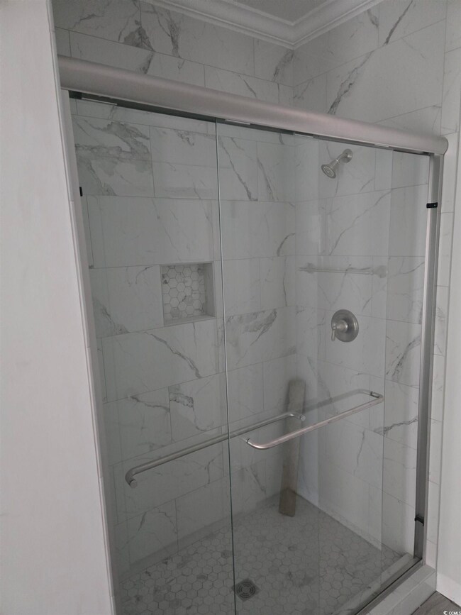 Bathroom featuring crown molding and walk in showe