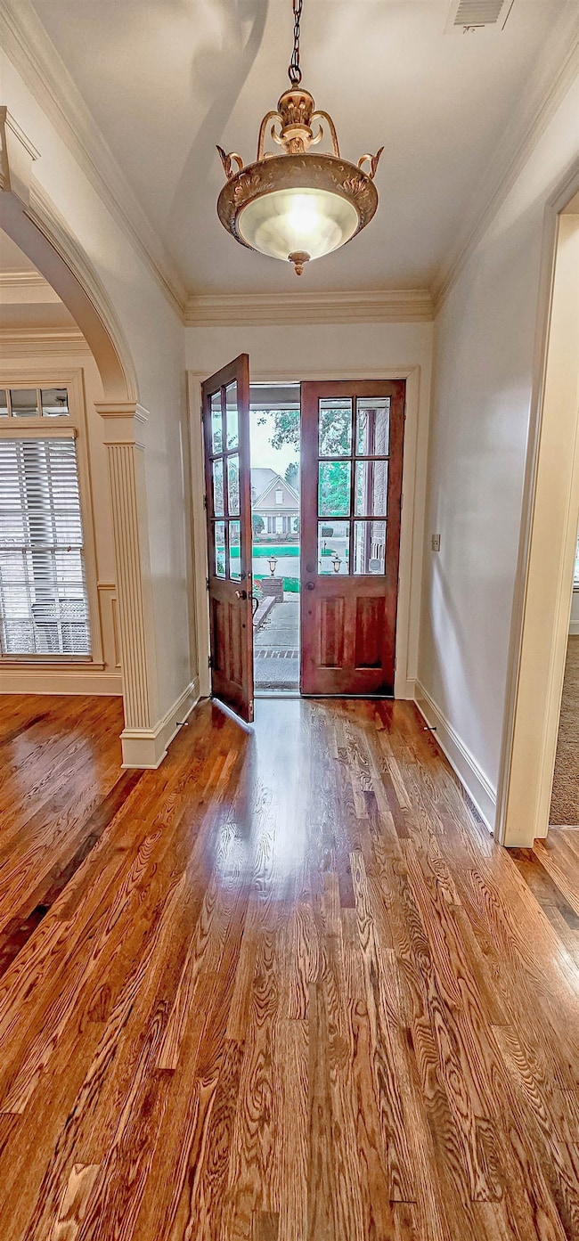 Doorway with hardwood / wood-style floors and crow