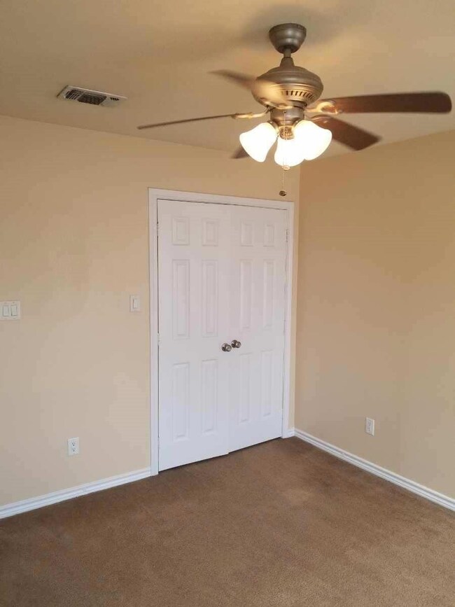 Unfurnished bedroom featuring ceiling fan, a close