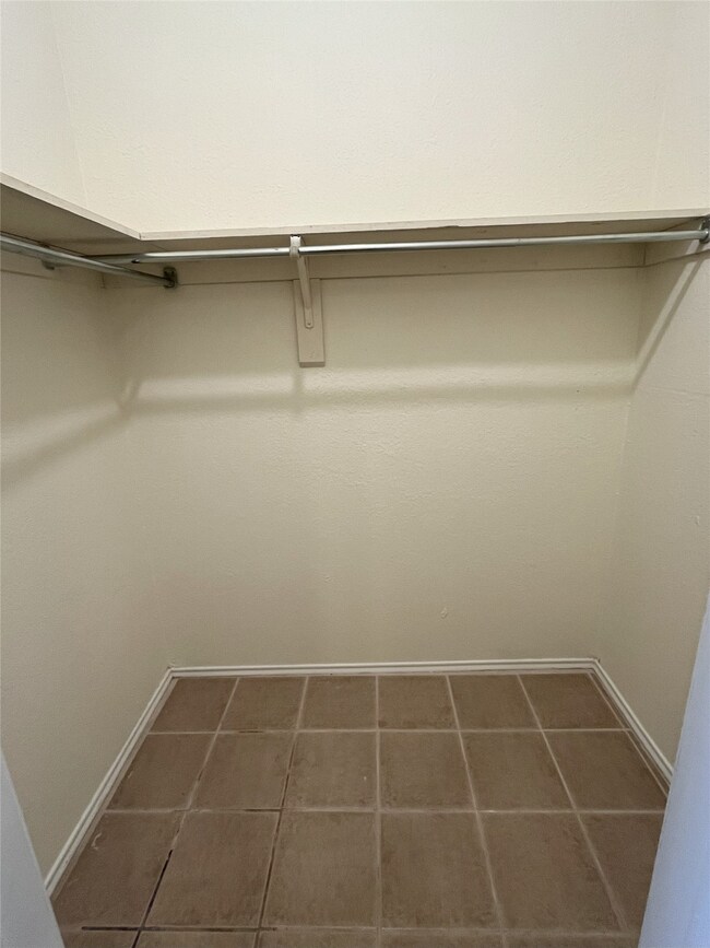 Walk in closet featuring dark tile patterned flooring