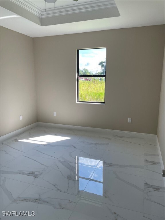 Unfurnished room featuring a tray ceiling and orna