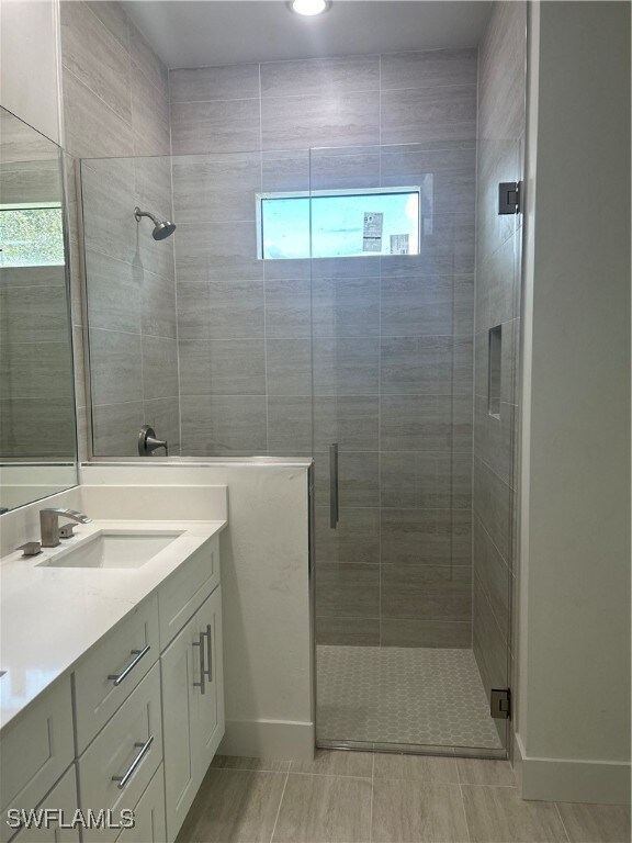 Bathroom featuring vanity and a shower with door