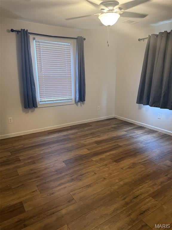 Empty room with dark wood-style floors and a ceiling fan