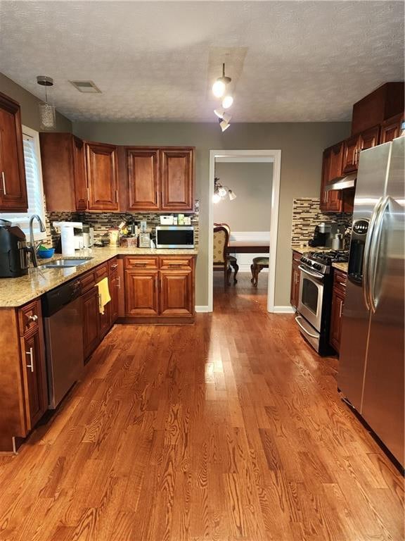 Kitchen featuring decorative backsplash, fridge, a textured ceiling, stove, and dishwashing machine
