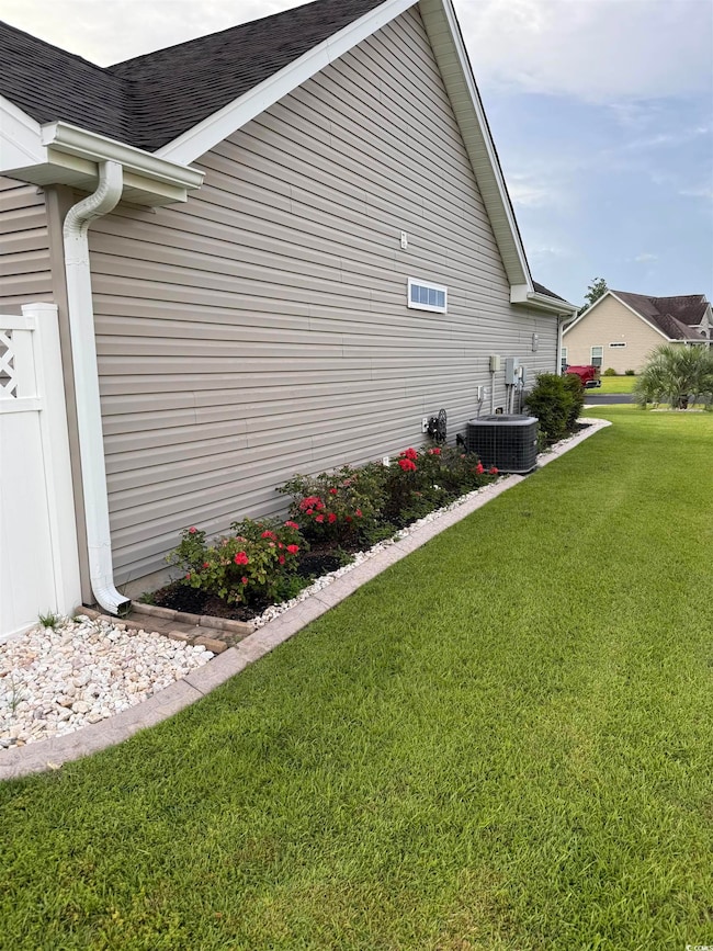 View of home's exterior featuring a lawn and roof with shingles
