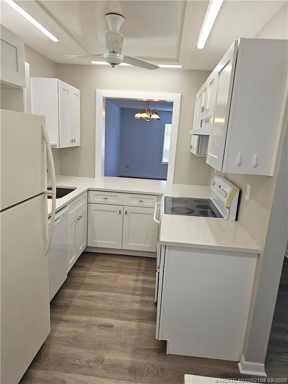 Beautifully updated kitchen with newer vinyl flooring, white cabinetry, white quartz countertops and white appliances