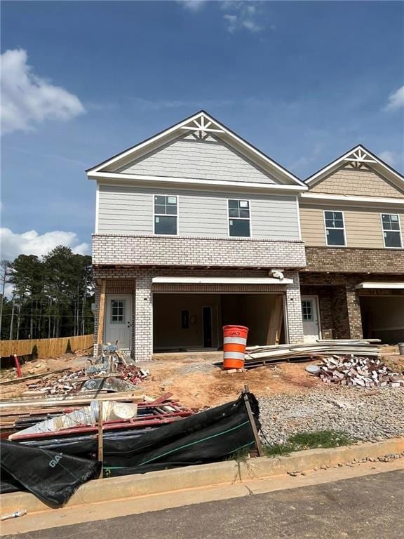 View of front of home featuring brick siding and a garage