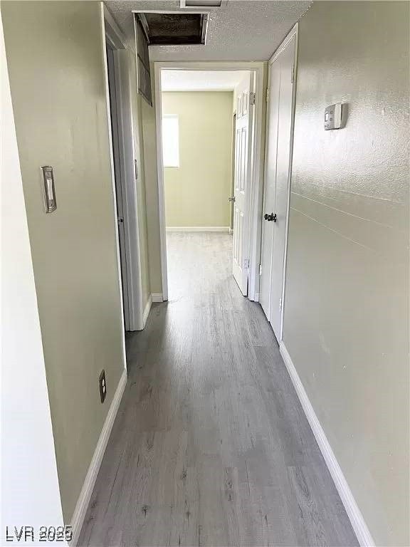 Corridor featuring wood finished floors, baseboard
